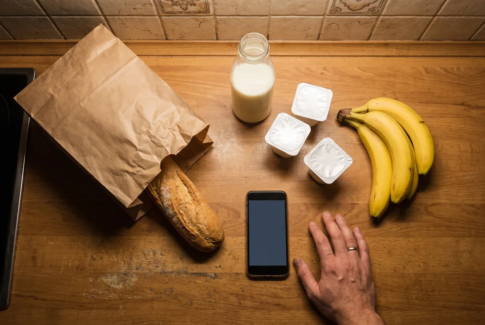 Małe zamówienie zakupów spożywczych na blacie kuchennym obok telefonu